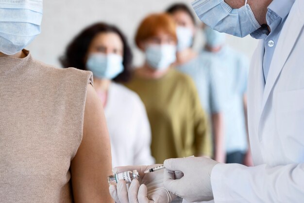 Woman getting vaccine shot by male medic