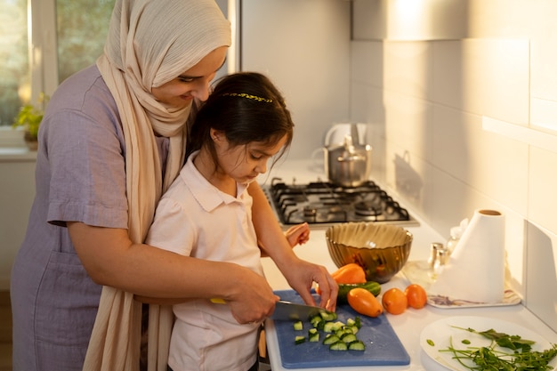 Foto gratuita donna e ragazza che cucinano vista laterale