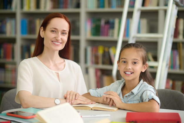 Free photo woman and girl doing lessons looking at camera