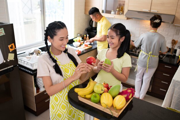 Woman and girl holding fruits