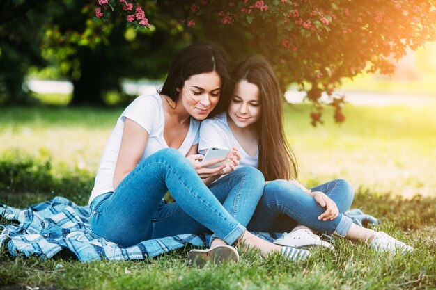 Woman and girl sitting under blooming tree