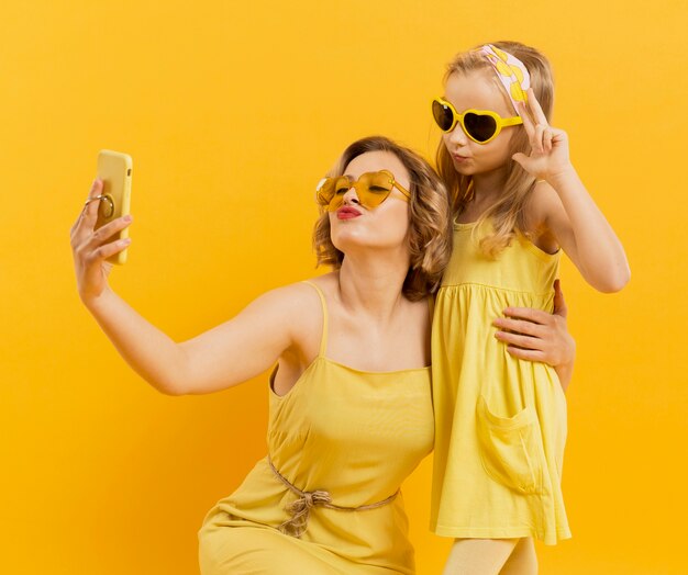 Woman and girl taking a selfie while wearing sunglasses