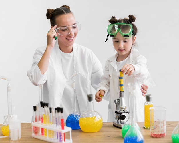 Woman and girl using science tubes