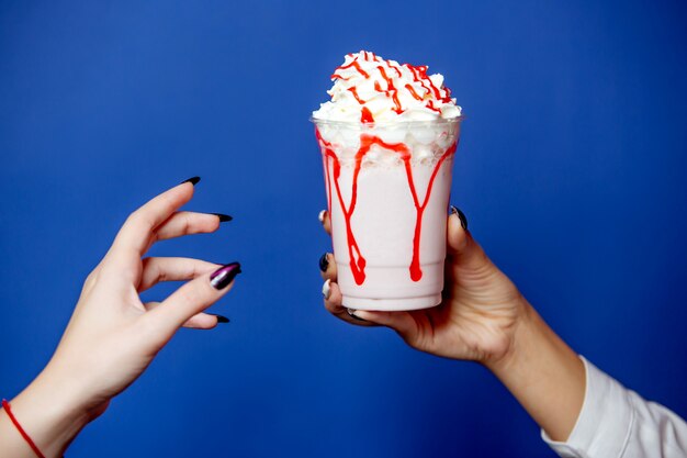 Woman gives milkshake with whipped cream on the top