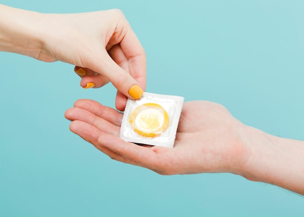 Woman giving a condom to another person