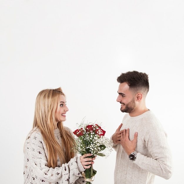 Woman giving flowers to man