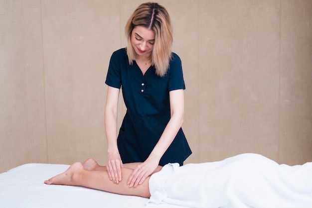 Woman giving foot massage at spa