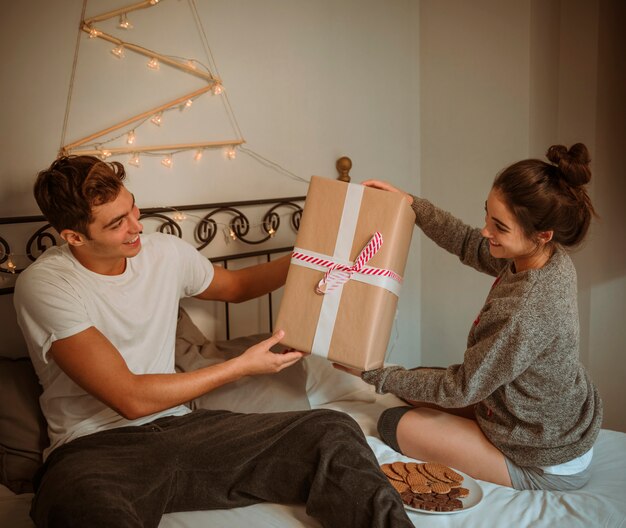 Woman giving gift box to man