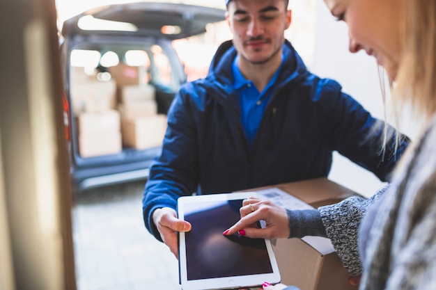 Woman giving online signature to deliveryman