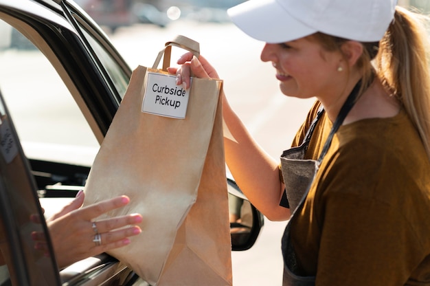 Woman giving an order at a curbside pickup outdoors