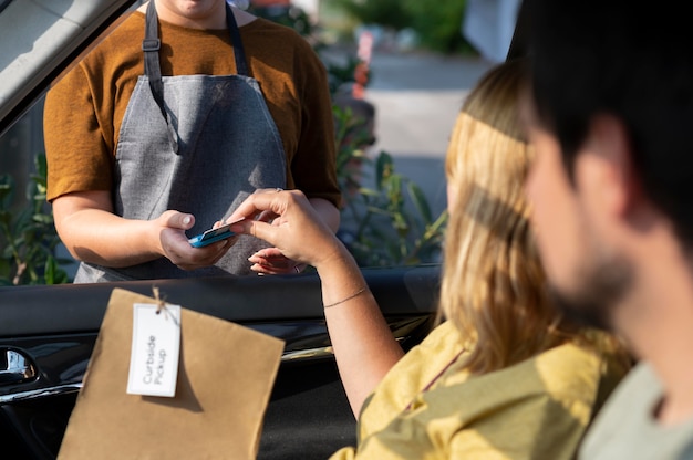 Woman giving an order at a curbside pickup outdoors