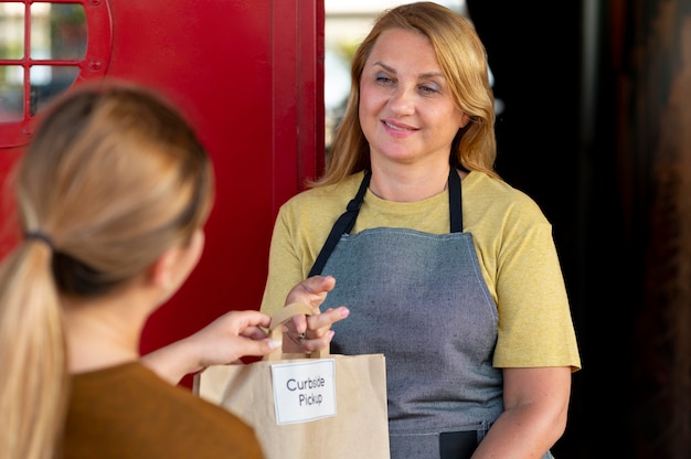 Woman giving an order at a curbside pickup outdoors