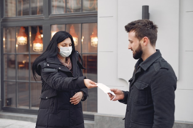 男に防護マスクを与える女性