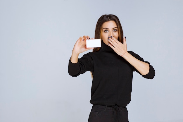 woman giving or receiving a business card and looks surprized. 