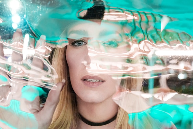 Woman behind glass wall looking at camera