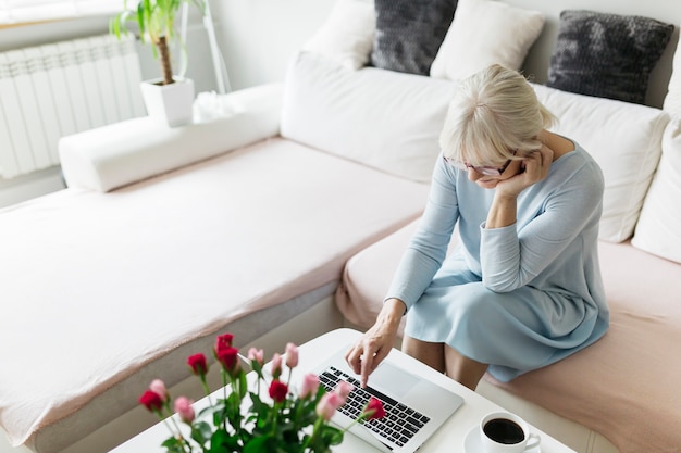 Foto gratuita donna in vetri usando il portatile