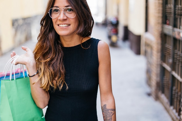 Free photo woman in glasses with paper bags