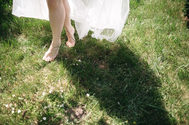 The woman goes barefoot on the grass