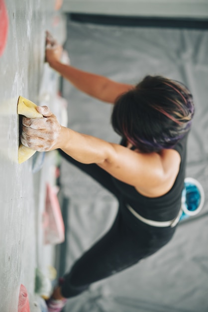 Woman grabbing boulder on climbing wall