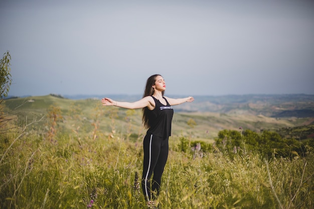 Woman in grass with hands apart