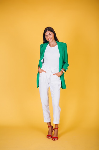 Woman in green jacket in studio on yellow background