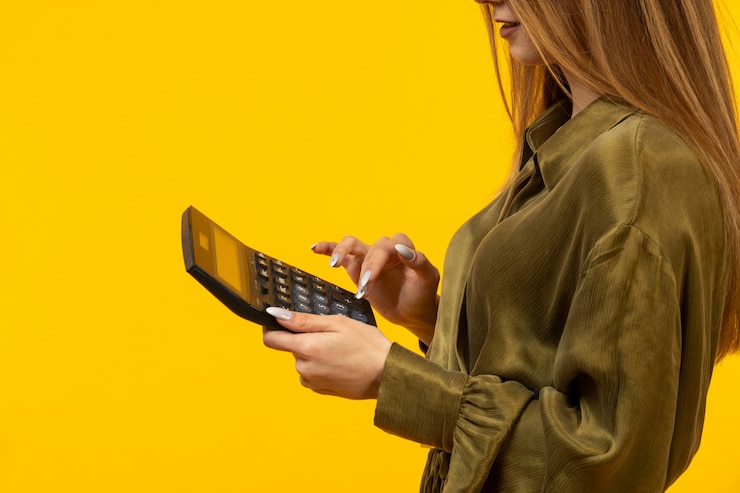 Free Photo woman in green pullover uses calculator