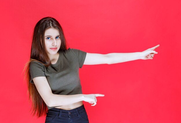 Woman in green shirt pointing at something on the east. 