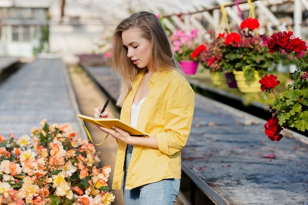 Free photo woman in greenhouse with agenda