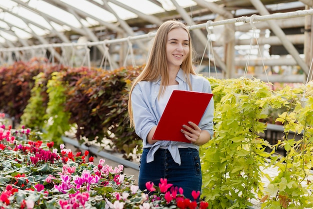 Woman in greenhouse with clipboard