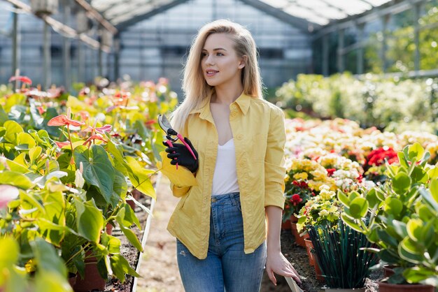 Woman in greenhouse with gardening scissors