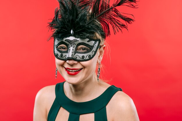 Woman in grey mask with feathers laughing 