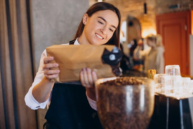 Woman grinding coffee in coffee machine