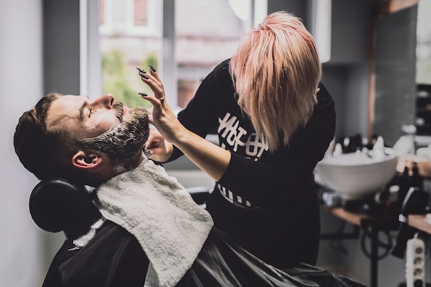 Woman grooming customer in salon