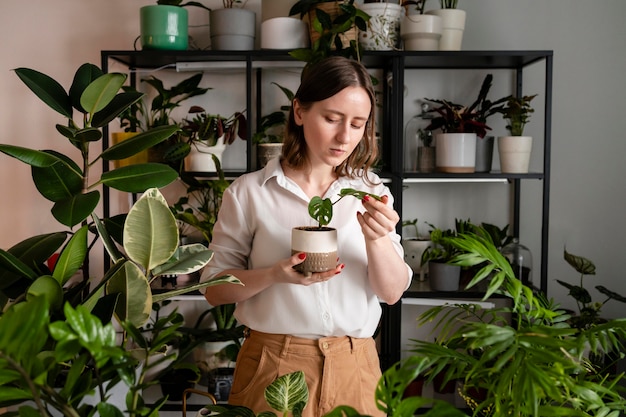 Foto gratuita donna che coltiva piante a casa