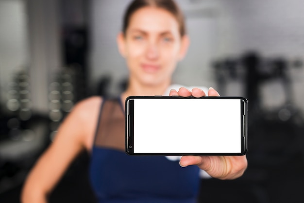 Foto gratuita donna in palestra con modello di smartphone