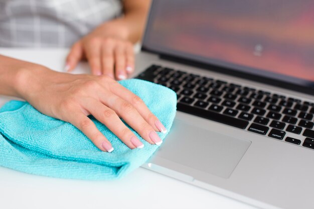 Woman hand cleaning laptop at home