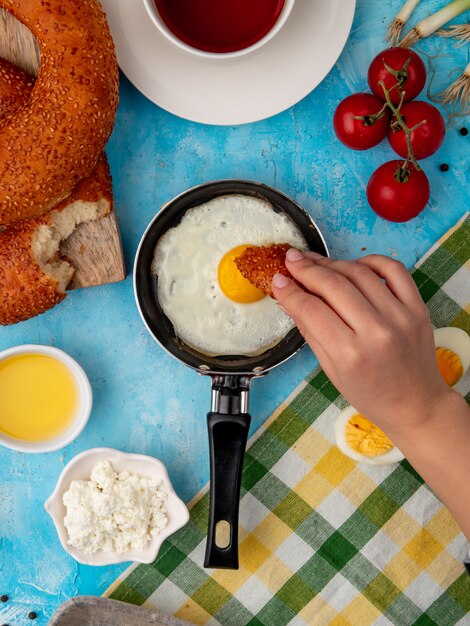 woman hand eating bread with fried egg