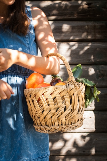 野菜のバスケットを持つ女性の手
