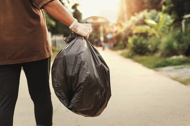 Woman hand holding garbage bag for recycle putting in to trash Premium Photo