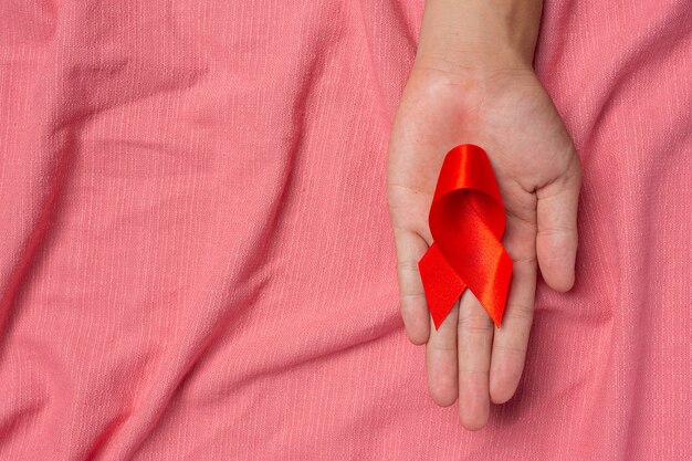 赤いリボンHIV意識の概念を持つ女性の手世界エイズデーと世界性的健康の日。