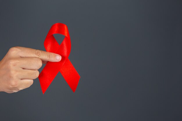 赤いリボンHIV意識の概念を持つ女性の手世界エイズデーと世界性的健康の日。