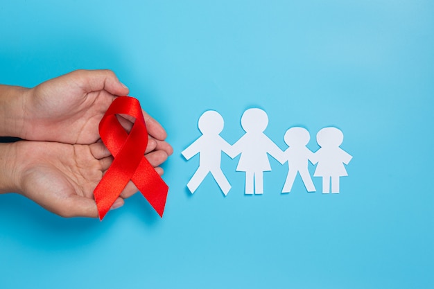 Woman hand holding red ribbon HIV awareness concept World AIDS Day and World Sexual Health Day.