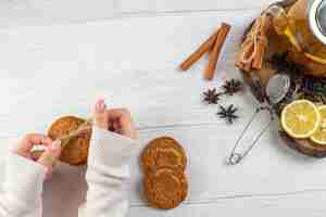 Foto gratuita mano della donna che tiene il tè nero impilato dei biscotti con il limone