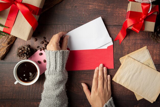 Woman hand is putting greeting card into envelope