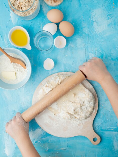 woman hand kneading dough on rolling board