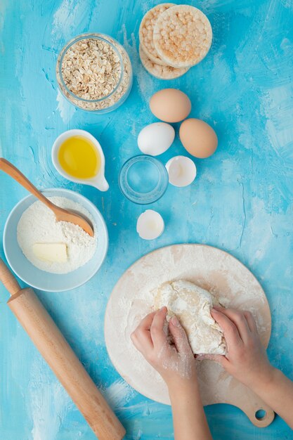 Woman hand kneading dough on rolling board