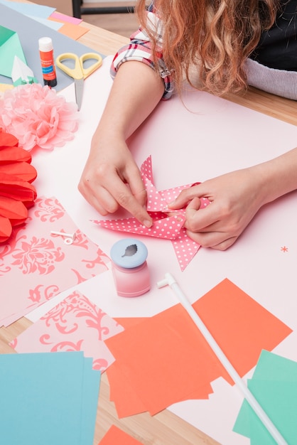 Woman hand making polka dotted origami pinwheel