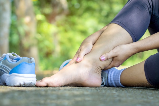 Premium Photo | Woman hand massaging her leg twisted ankle broken