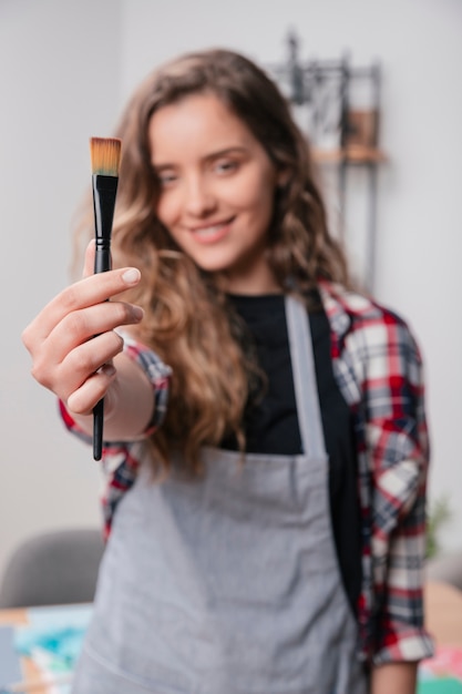 Woman hand showing black unused paintbrush