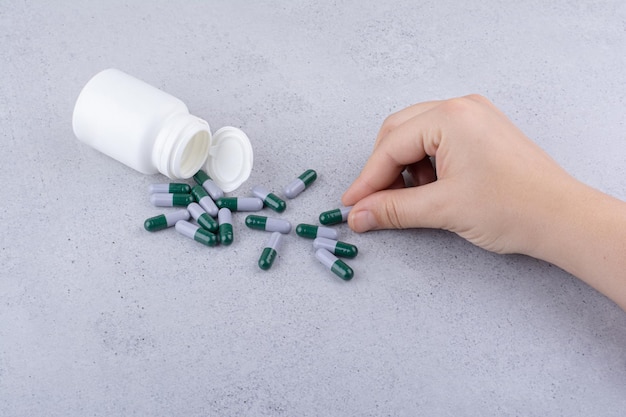 Woman hand taking medical capsule out of bottle. High quality photo